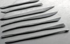 Mehrere schmale Modellier- oder Tonwerkzeuge nebeneinander auf hellem Untergrund.